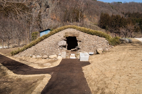 復元された240号墳の写真です。墳丘が復元され、古墳の手前には整備された歩道が写っています。